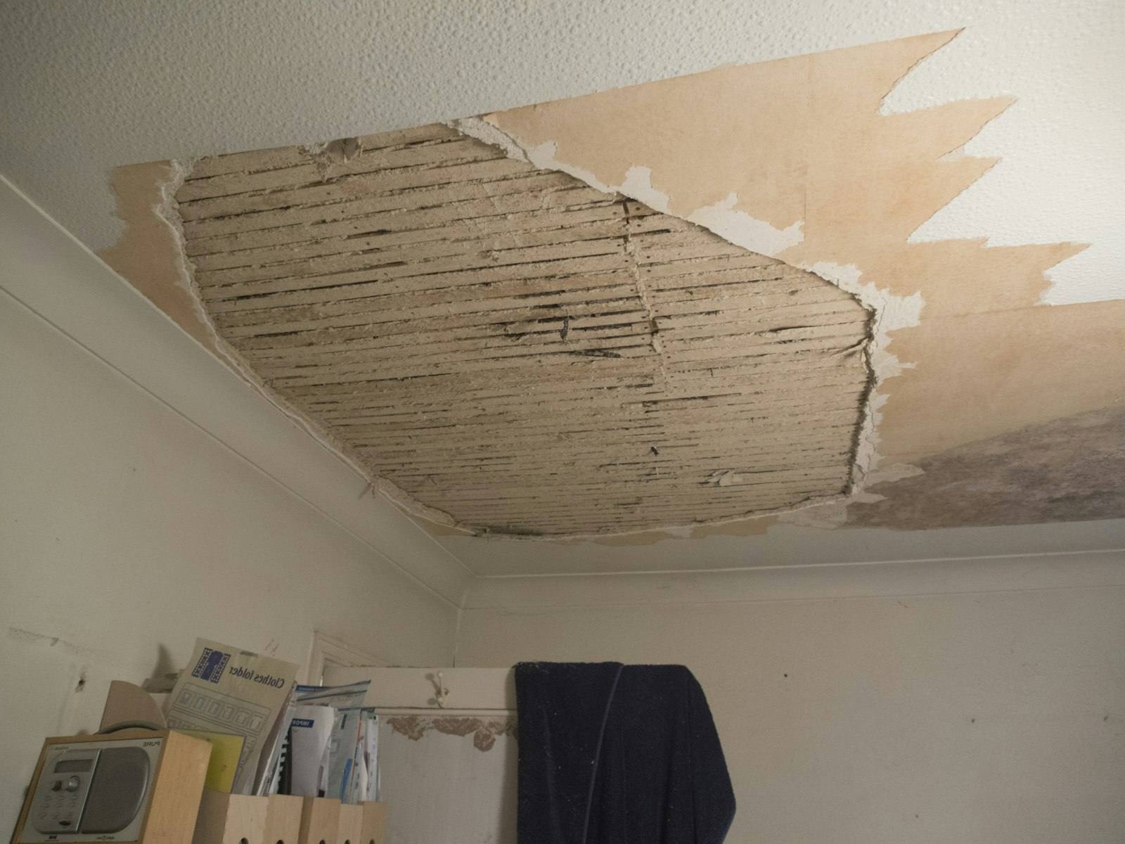 Water-damaged ceiling torn open after a leak in a home